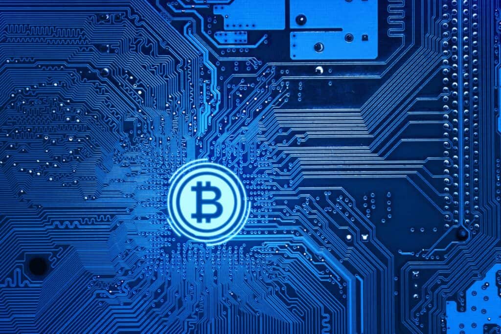 תקריב של לוח מעגלים עם סמל ביטקוין במרכז.